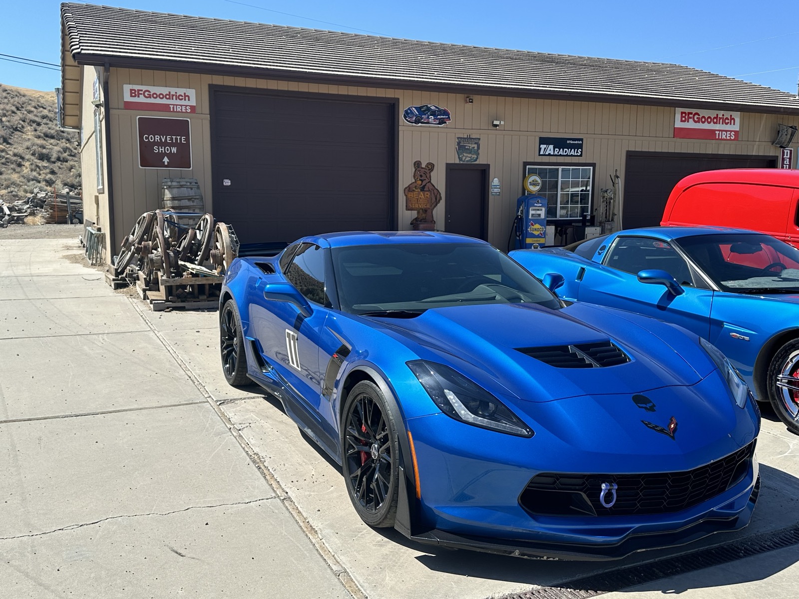 Blue C8 Corvette front three-quarter parked outside the shop, deep gloss finish