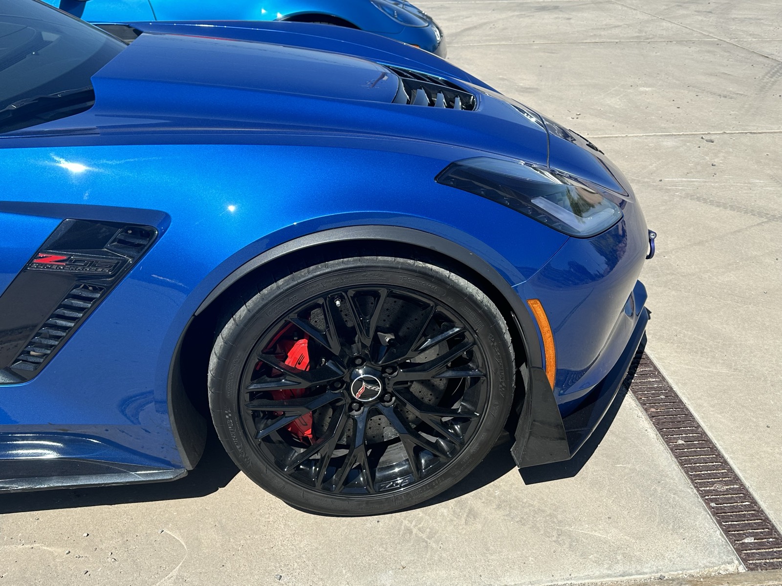 C8 Corvette wheel and red brake caliper close-up after cleaning