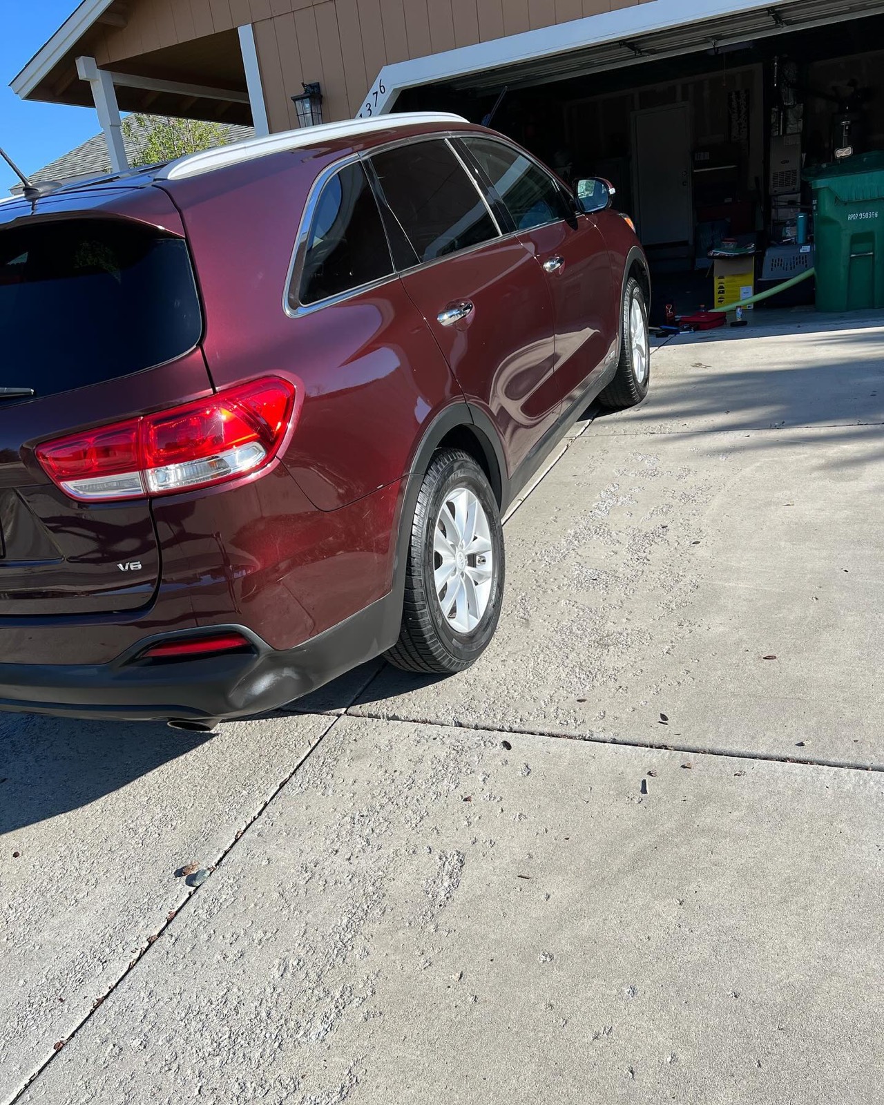 Burgundy Kia Sorento rear three-quarter after a full detail